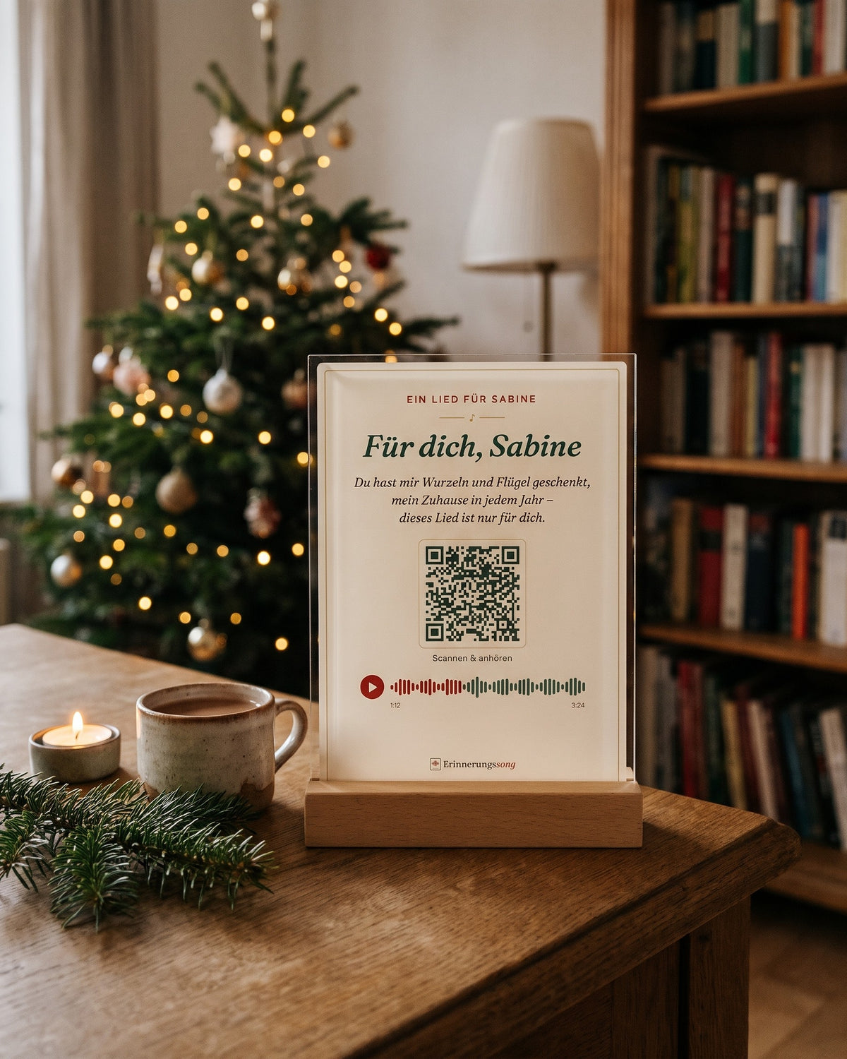 Acryl-Aufsteller mit Songtitel, Refrain und QR-Code auf einem Sideboard vor dem Weihnachtsbaum (Beispiel, Name erfunden)